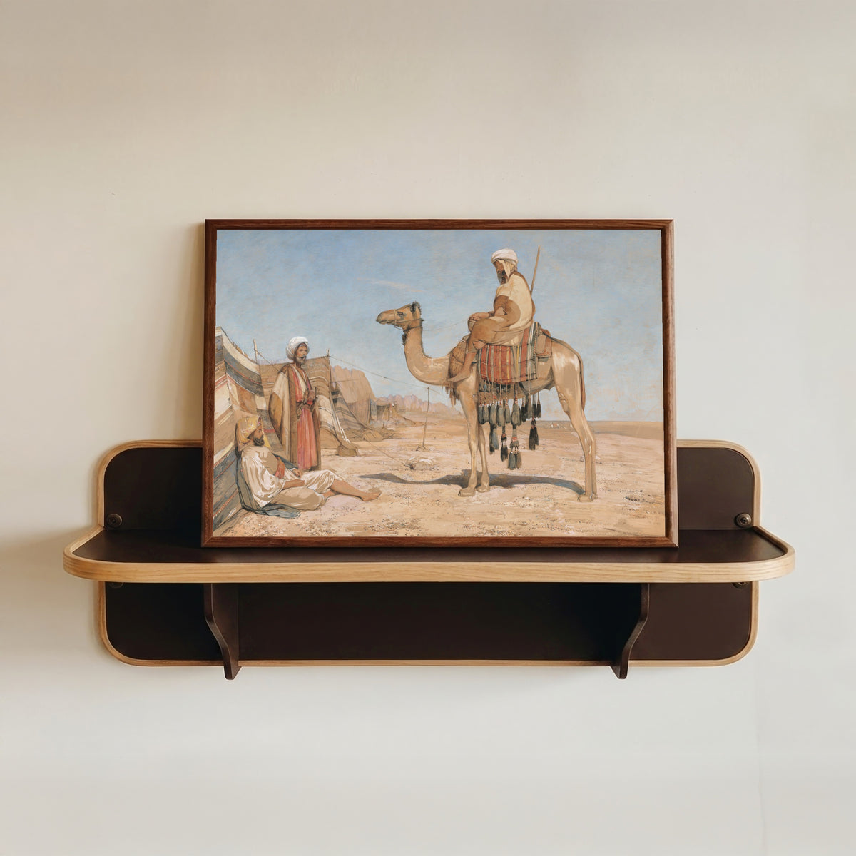 Framed art print of A Bedouin Encampment; or, Bedouin Arabs by John Frederick Lewis, in a dark wood frame resting on a wall shelf