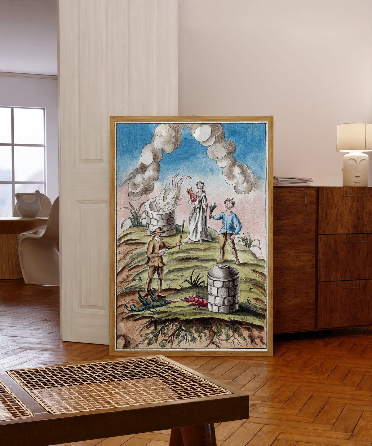 Framed art print of A Body Consumed by a Furnace, and Two Dragons… by After Nicolas Flamel, in a light wood frame leaning in a warm room with a parquet floor