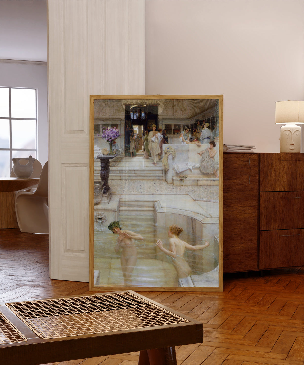 Framed art print of A Favourite Custom by Lawrence Alma-Tadema, in a light wood frame leaning in a warm room with a parquet floor