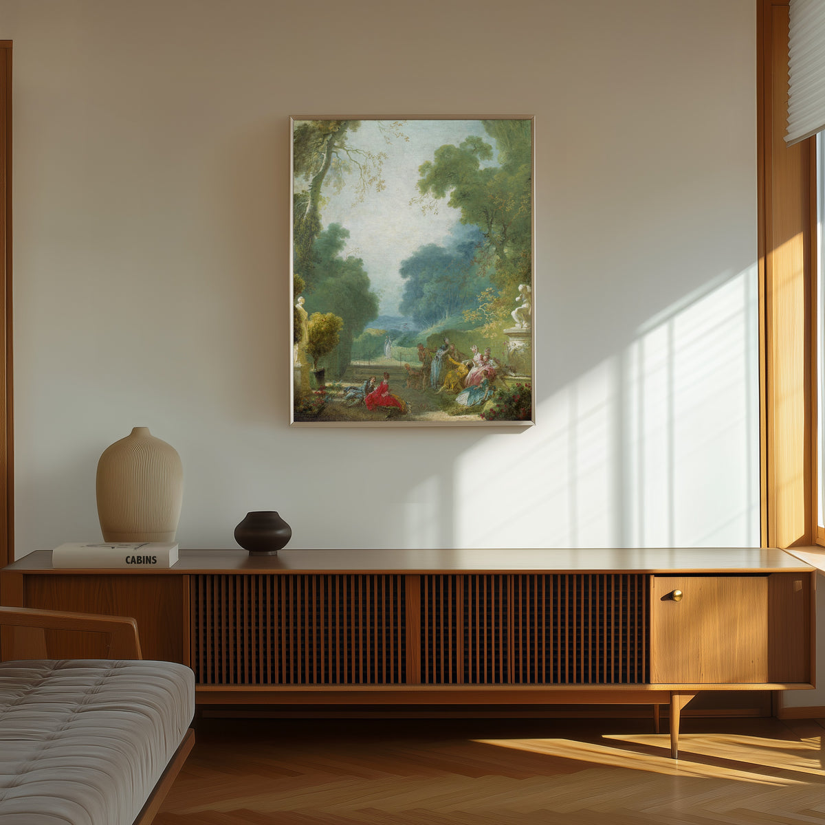 Framed art print of A Game of Hot Cockles by Jean-Honoré Fragonard, in a thin light frame on a sunlit wall above a wooden sideboard