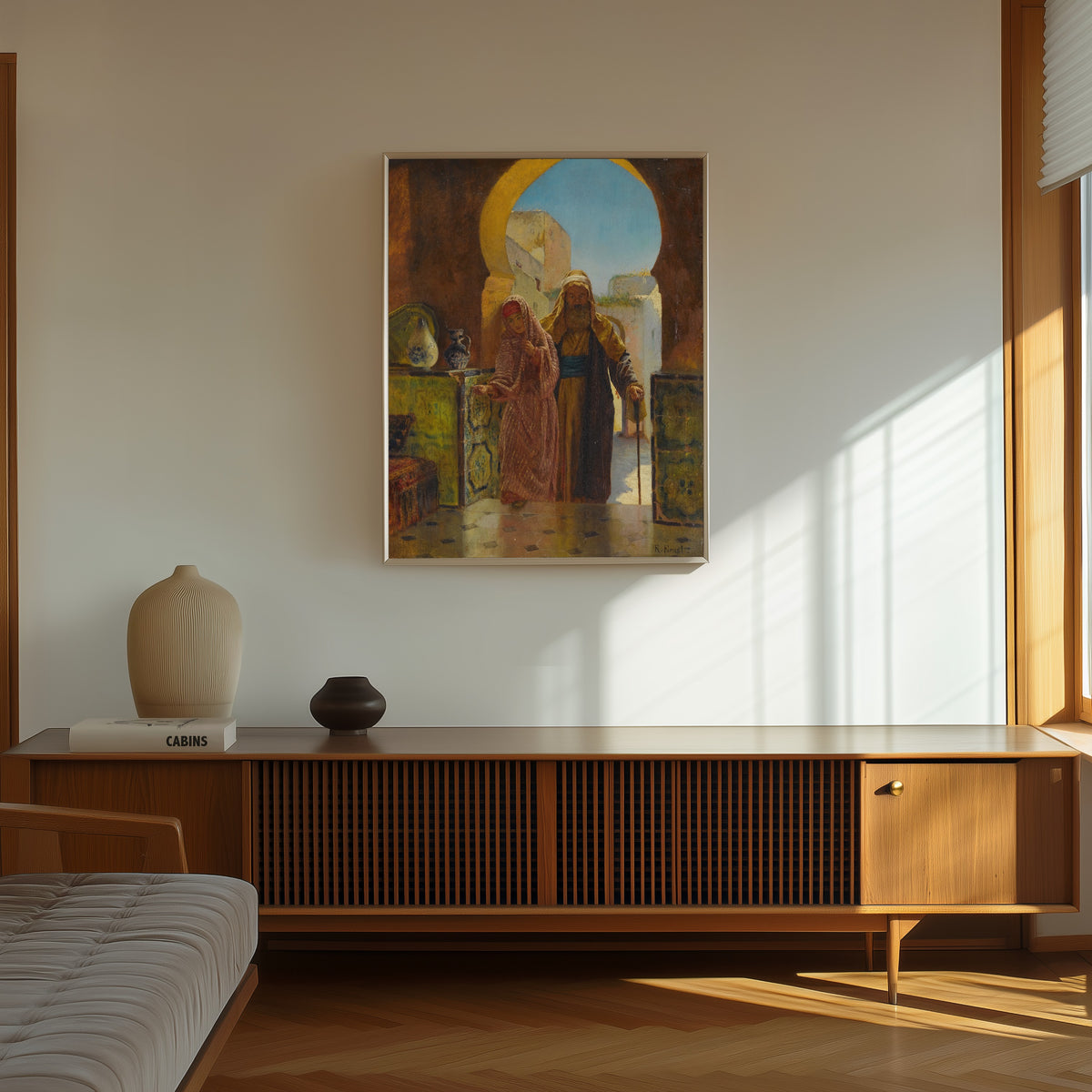 Framed art print of A Helping Hand by Rudolf Ernst, in a thin light frame on a sunlit wall above a wooden sideboard