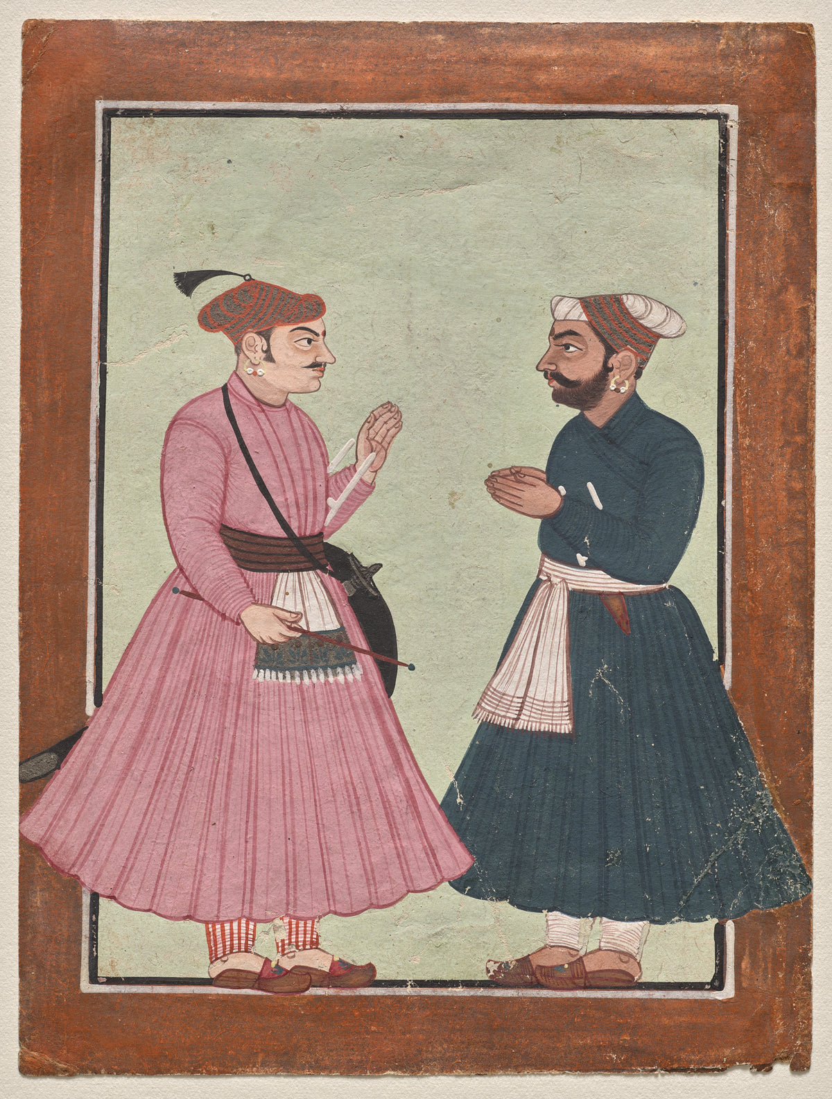 A Mandi Royal Family Member Receives a Noble by Pahari school — Two men in long jamas greet each other on a pale green ground