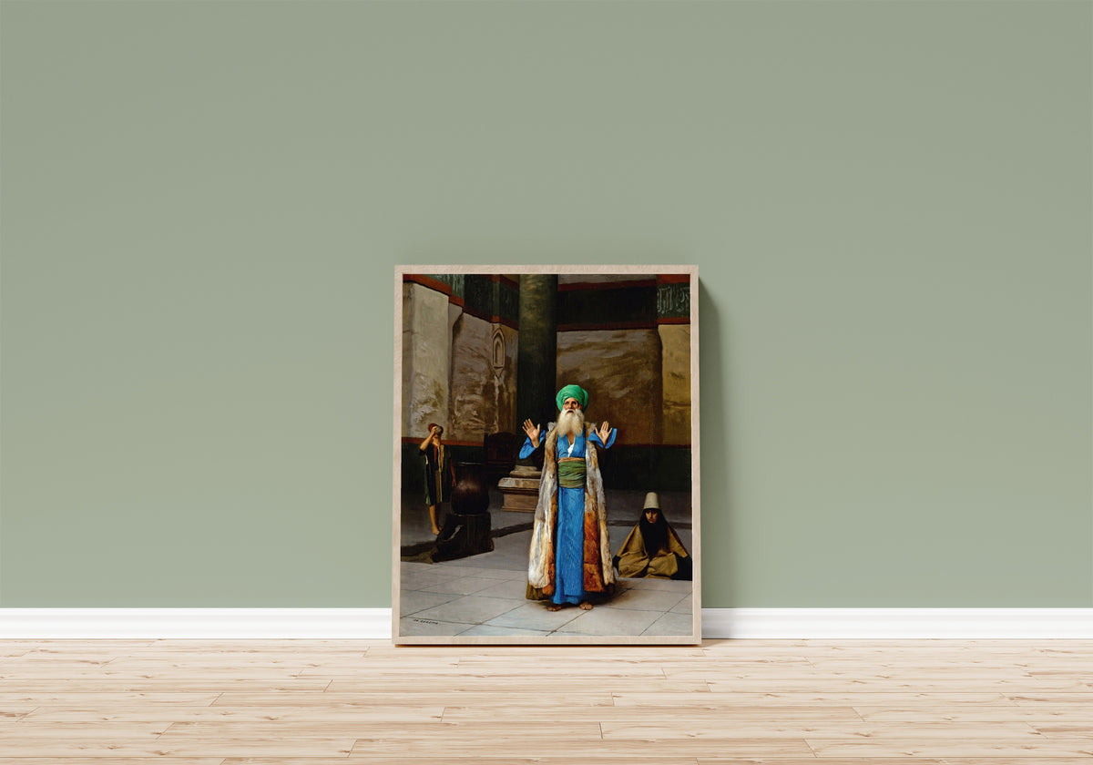 Framed art print of A Sultan at Prayer by Jean-Léon Gérôme, in a light wood frame leaning on a sage green wall above a wooden floor