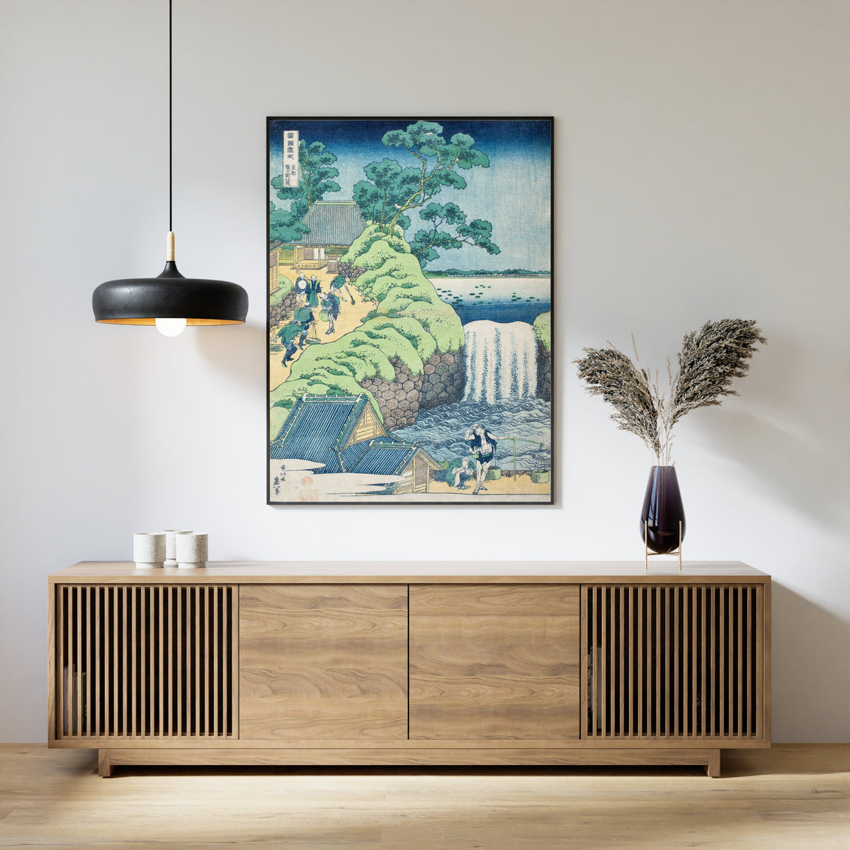 Framed art print of A Tour of the Waterfalls of the Provinces: Aoigaoka Falls in the Eastern Capital by Katsushika Hokusai, above a slatted wood sideboard