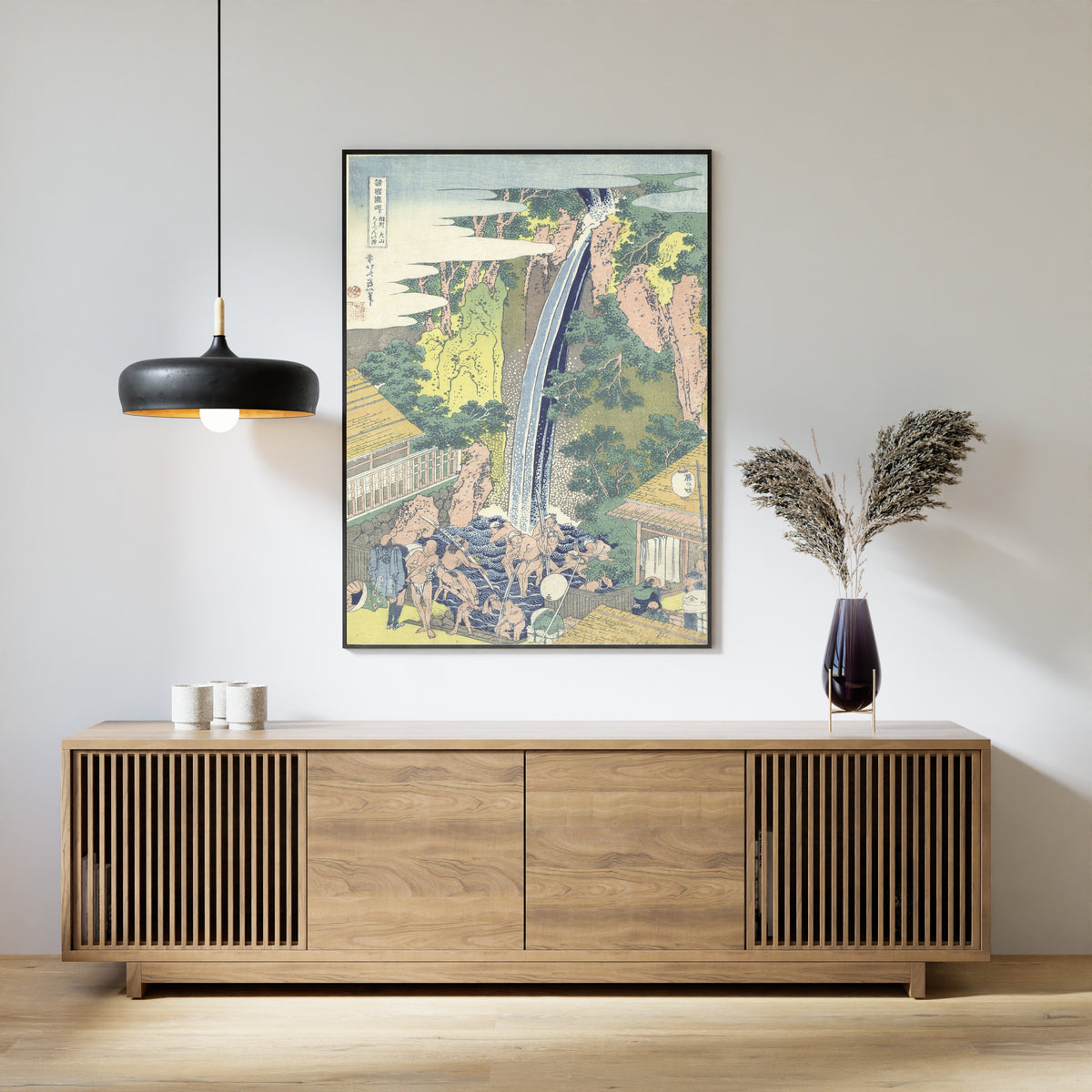 Framed art print of A Tour of the Waterfalls of the Provinces: Rōben Waterfall at Ōyama in Sagami Province by Katsushika Hokusai, above a slatted wood sideboard