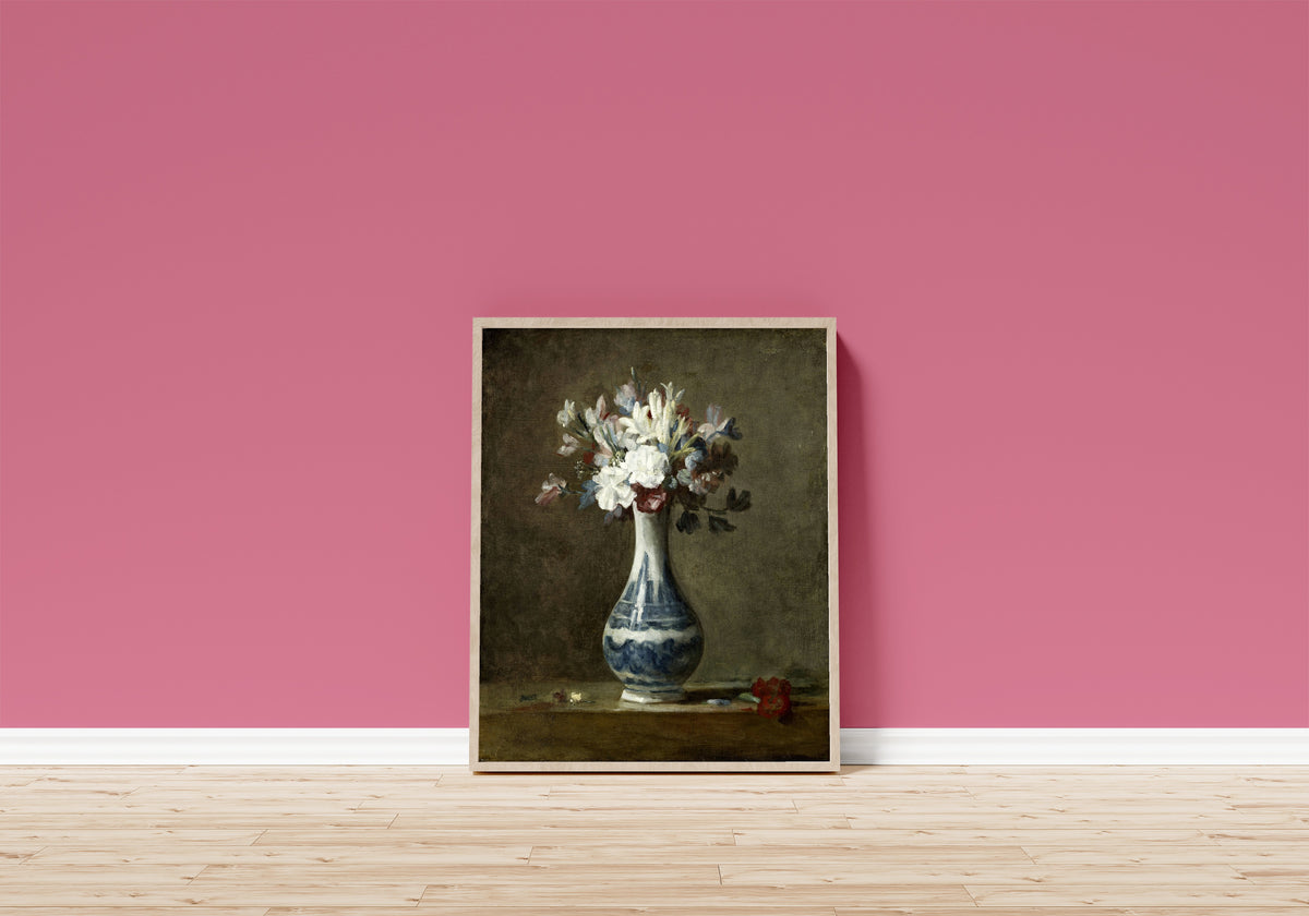 Framed art print of A Vase of Flowers by Jean-Siméon Chardin, in a light wood frame leaning on a pink wall above a wooden floor
