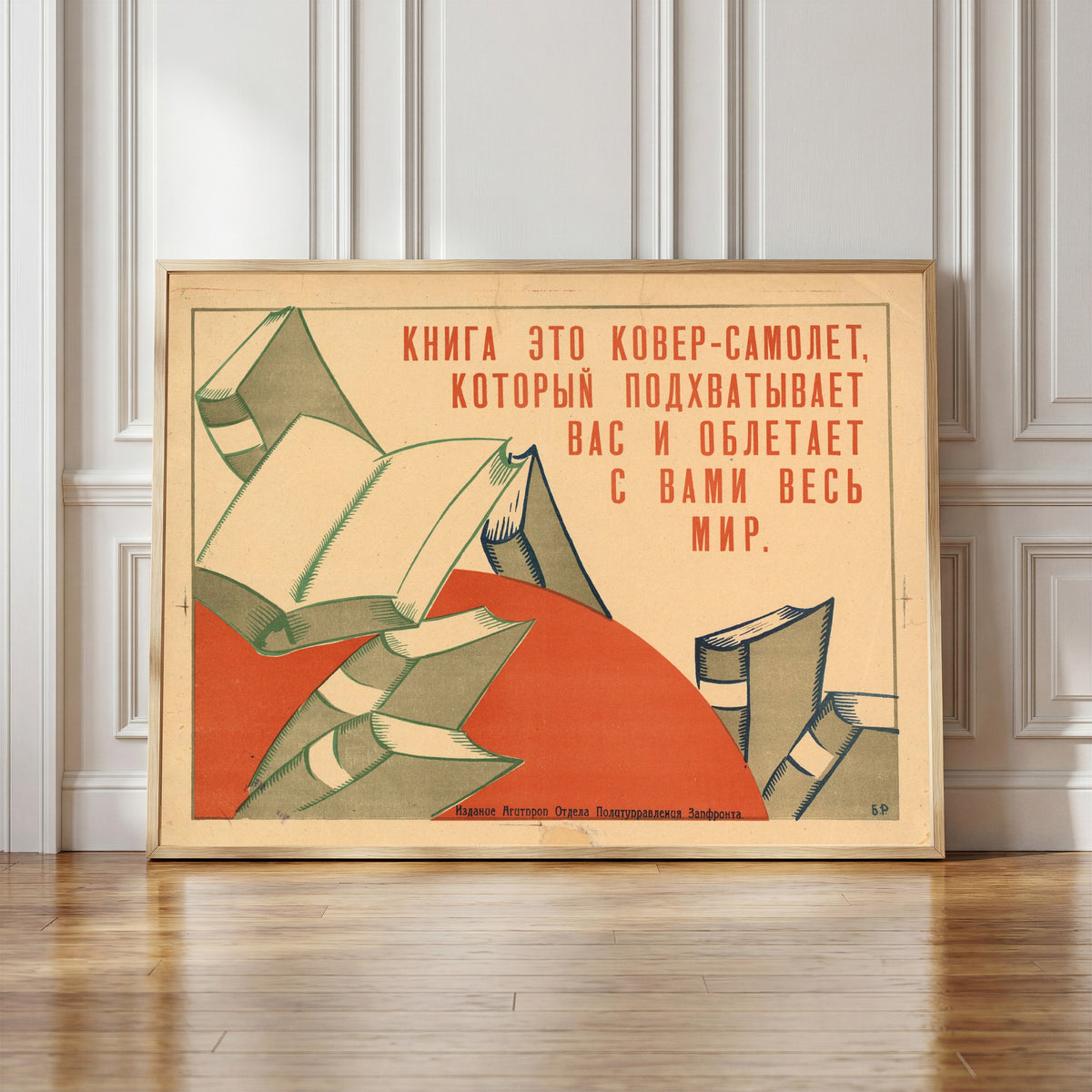 Framed art print of A book is a magic carpet that sweeps you up and carries you around the whole…, in a light wood frame leaning against a panelled white wall