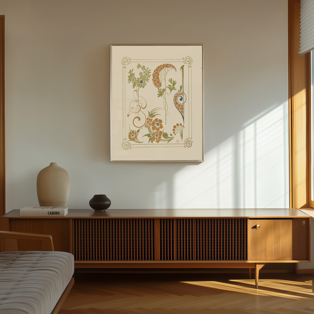 Framed art print of Abstract design based on flowers and arabesques by Alphonse Mucha, in a thin light frame on a sunlit wall above a wooden sideboard