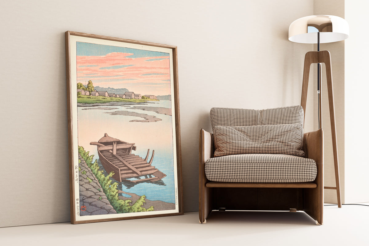 Framed art print of Akita Tsuchizaki by Kawase Hasui, leaning against a wall beside an armchair and a floor lamp