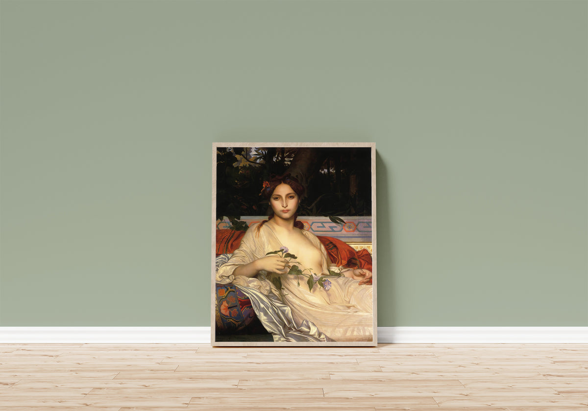 Framed art print of Albaydé by Alexandre Cabanel, in a light wood frame leaning on a sage green wall above a wooden floor