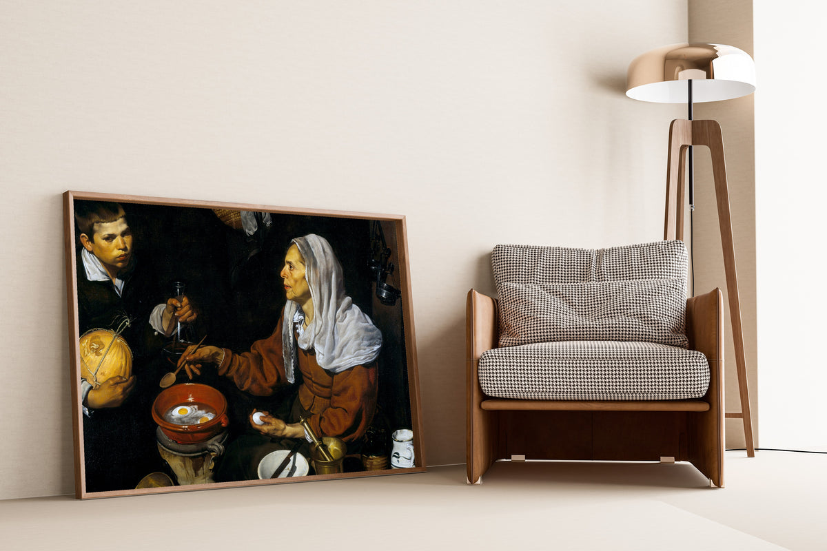 Framed art print of An Old Woman Cooking Eggs by Diego Velázquez, leaning against a wall beside an armchair and a floor lamp
