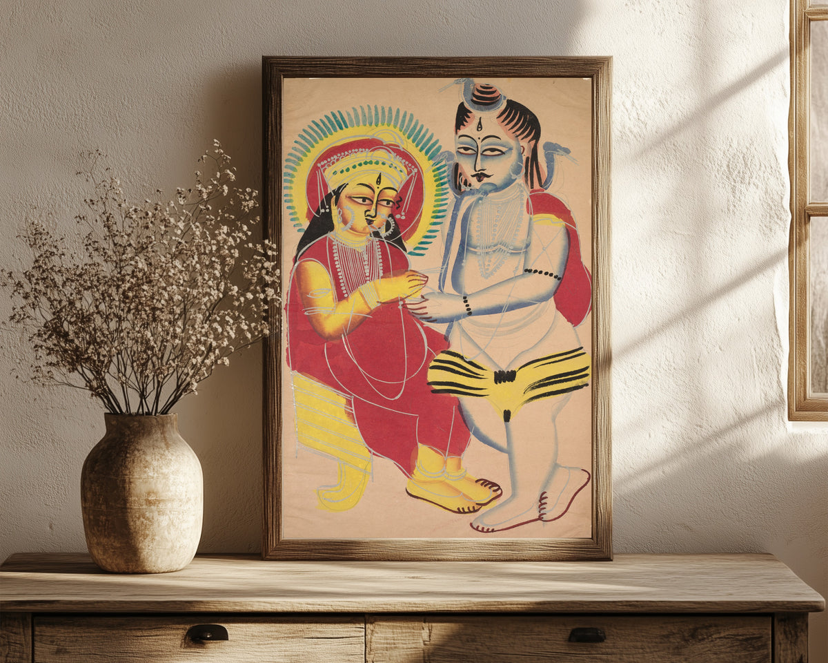 Framed art print of Annapurna and Shiva by Kalighat painter, in a dark wood frame leaning on a rustic console beside dried flowers