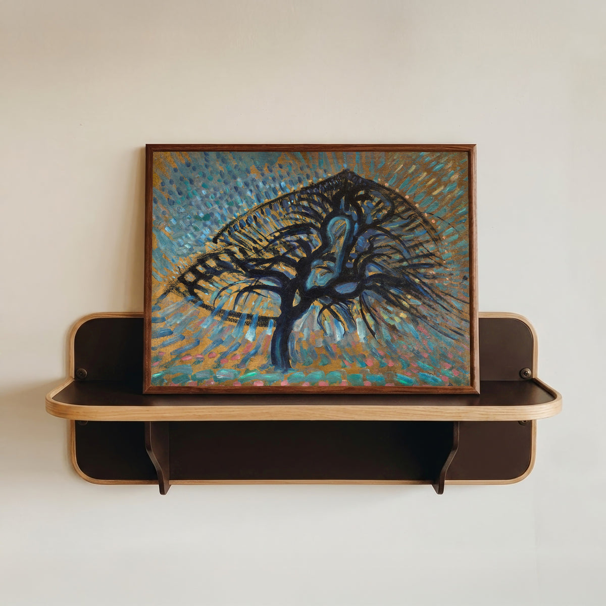 Framed art print of Apple Tree, Pointillist Version by Piet Mondrian, in a dark wood frame resting on a wall shelf