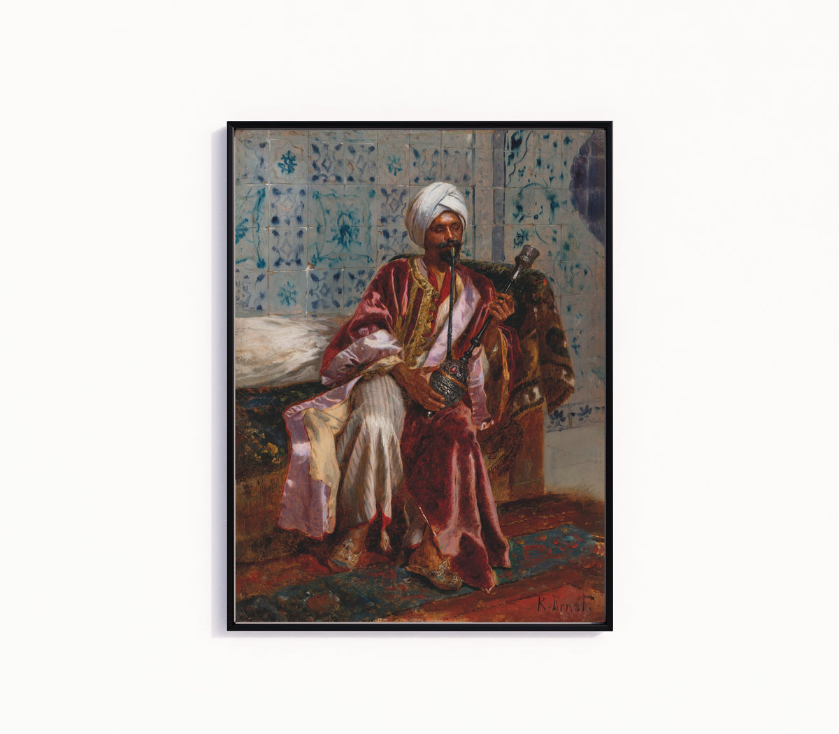 Framed art print of Arab smoking a nargilah by Rudolf Ernst, in a slim black frame on a plain white wall