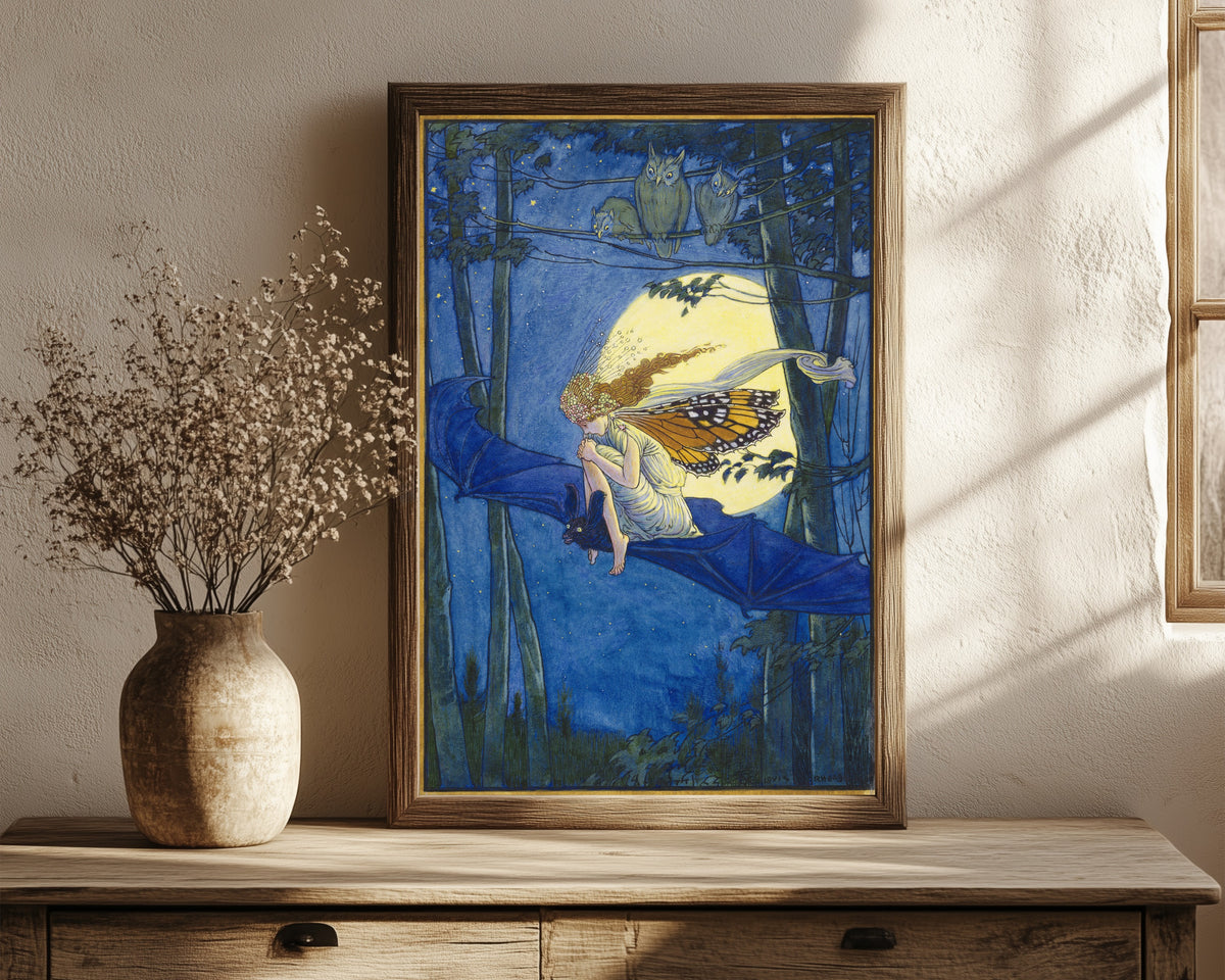 Framed art print of Ariel on a Bat's Back by Louis Rhead, in a dark wood frame leaning on a rustic console beside dried flowers