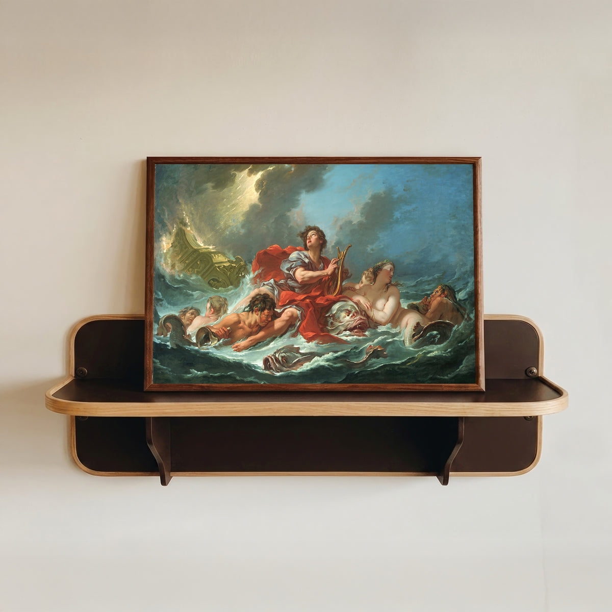 Framed art print of Arion on the Dolphin by François Boucher, in a dark wood frame resting on a wall shelf