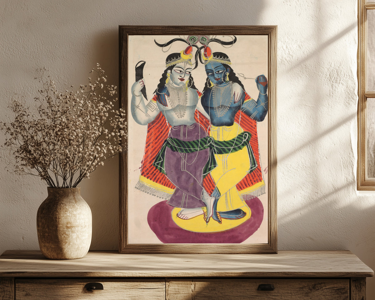Framed art print of Balarama and Krishna by Kalighat painter, in a dark wood frame leaning on a rustic console beside dried flowers