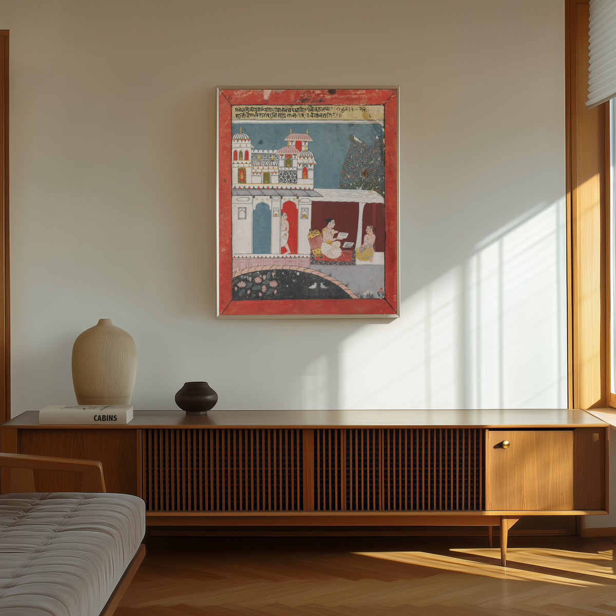 Framed art print of Bangala Ragini by Malwa school, in a thin light frame on a sunlit wall above a wooden sideboard