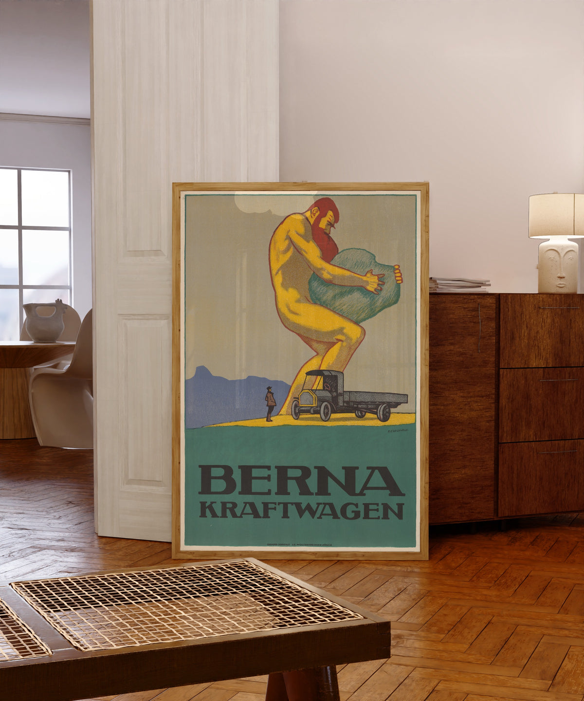 Framed art print of Berna Kraftwagen by Emil Cardinaux, in a light wood frame leaning in a warm room with a parquet floor
