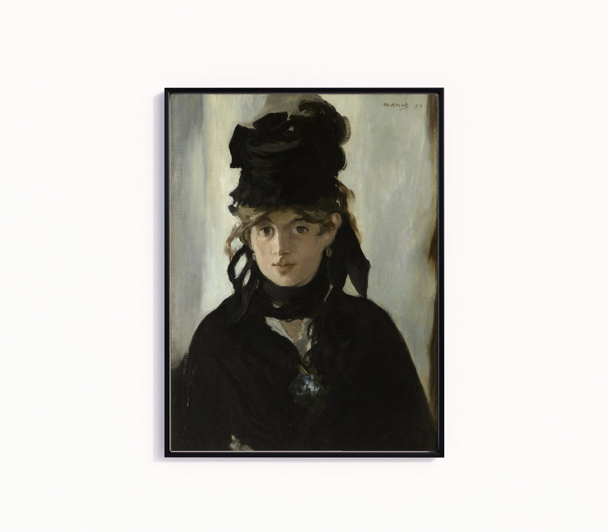 Framed art print of Berthe Morisot with a Bouquet of Violets by Édouard Manet, in a slim black frame on a plain white wall