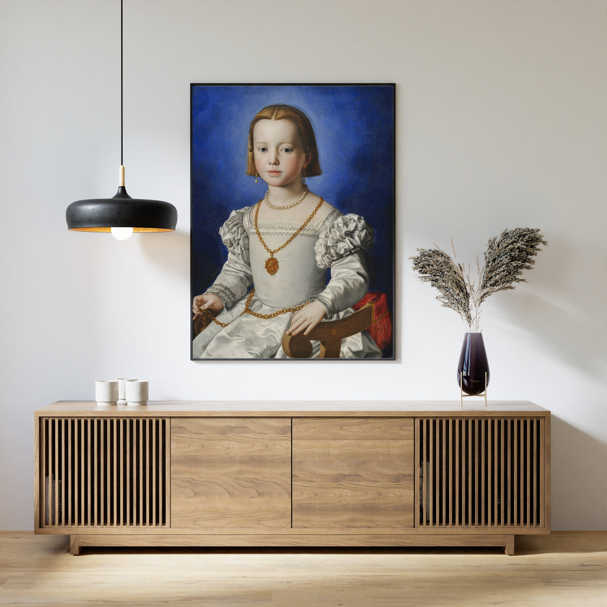 Framed art print of Bia di Cosimo de’ Medici by Bronzino, above a slatted wood sideboard