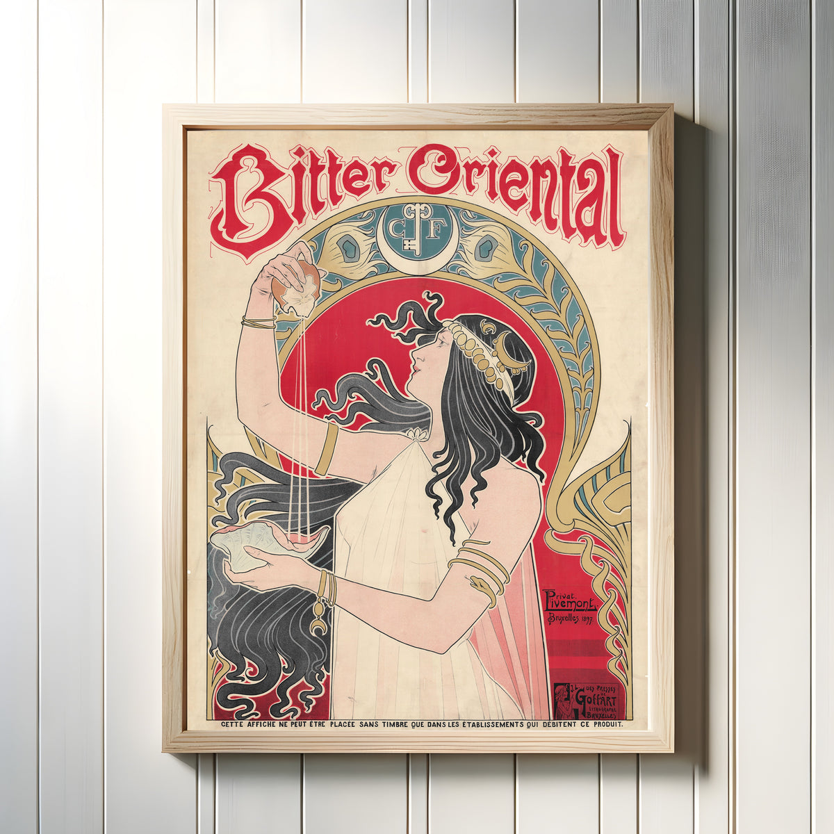 Framed art print of Bitter Oriental by Henri Privat-Livemont, in a light wood frame on a white panelled wall