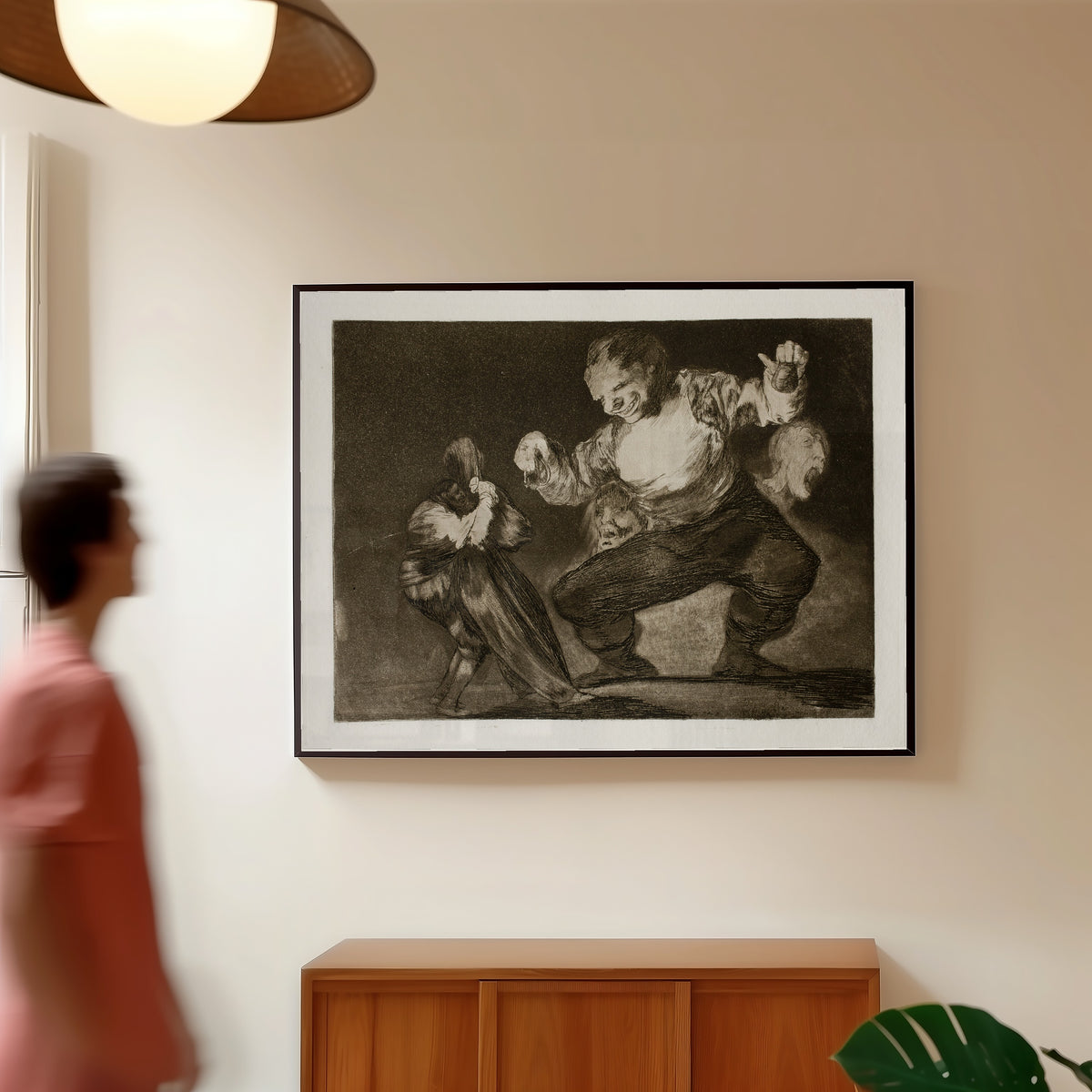 Framed art print of Bobalicón (Simpleton), from Los Disparates by Francisco de Goya, in a slim black frame on a warm wall in a sunlit room