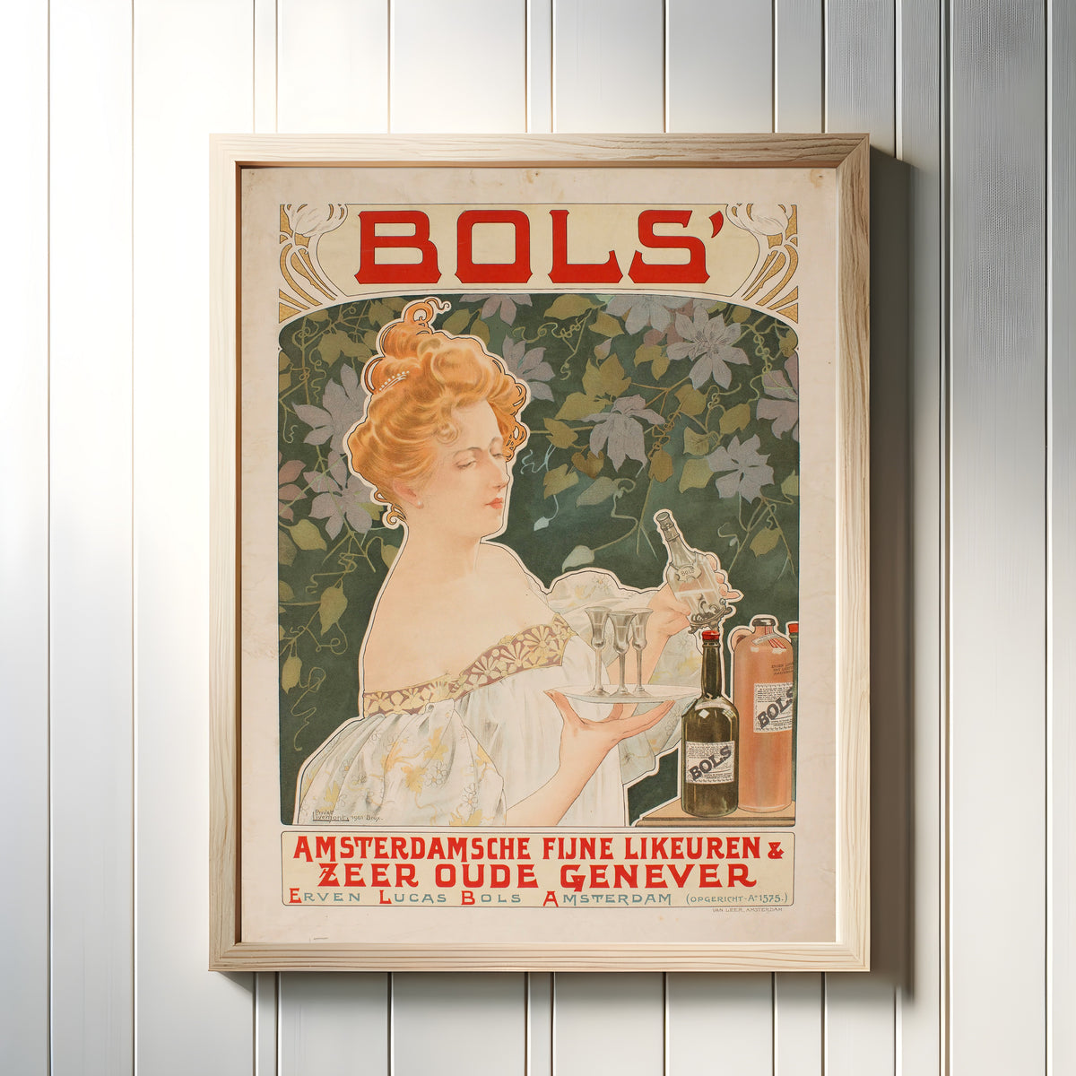 Framed art print of Bols' Amsterdamsche Fijne Likeuren by Henri Privat-Livemont, in a light wood frame on a white panelled wall