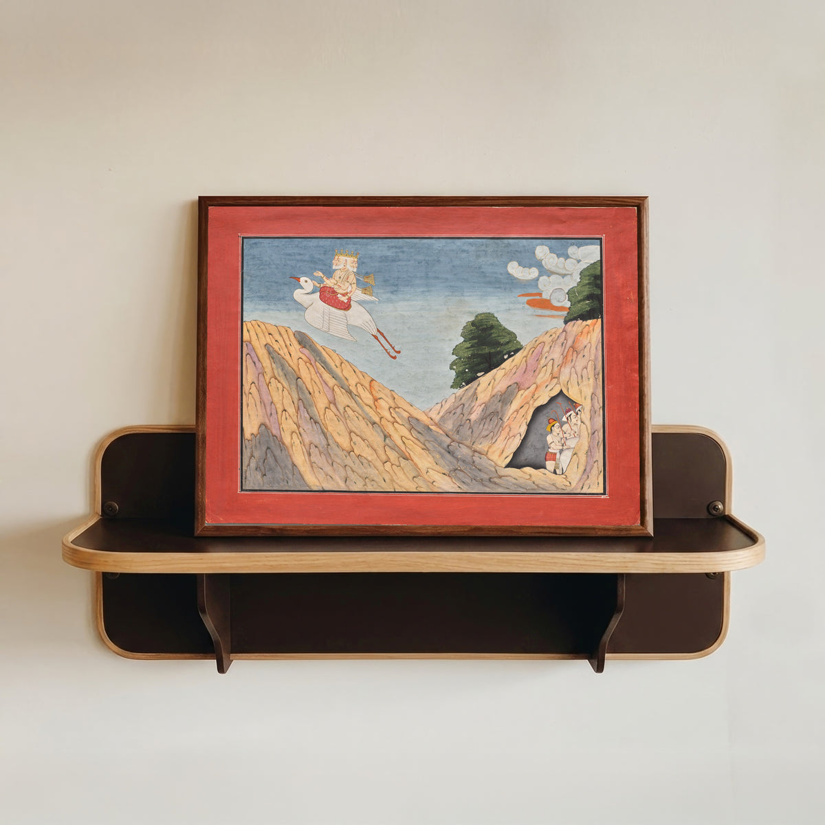 Framed art print of Brahma Hides the Cowherds and the Calves in the Cave by Basohli school, in a dark wood frame resting on a wall shelf