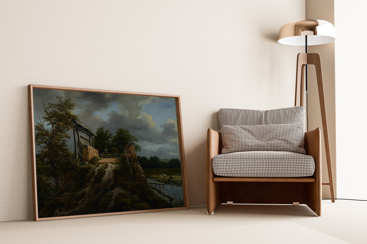 Bridge with a Sluice by Jacob van Ruisdael — framed and leaning against a wall beside an armchair and a floor lamp