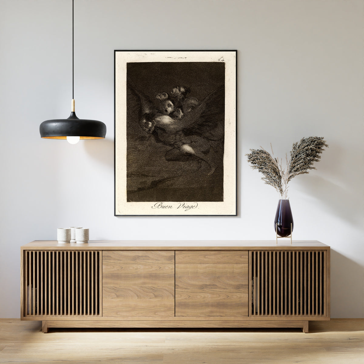 Framed art print of Buen Viage (Bon Voyage), Los Caprichos, Plate 64 by Francisco de Goya, above a slatted wood sideboard