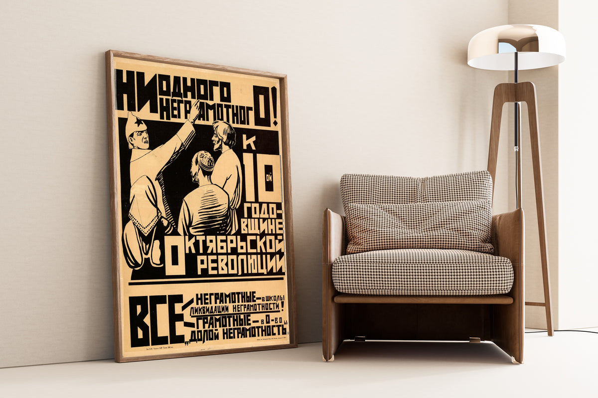 Framed art print of By the 10th Anniversary of the October Revolution, Not a Single Illiterate!, leaning against a wall beside an armchair and a floor lamp