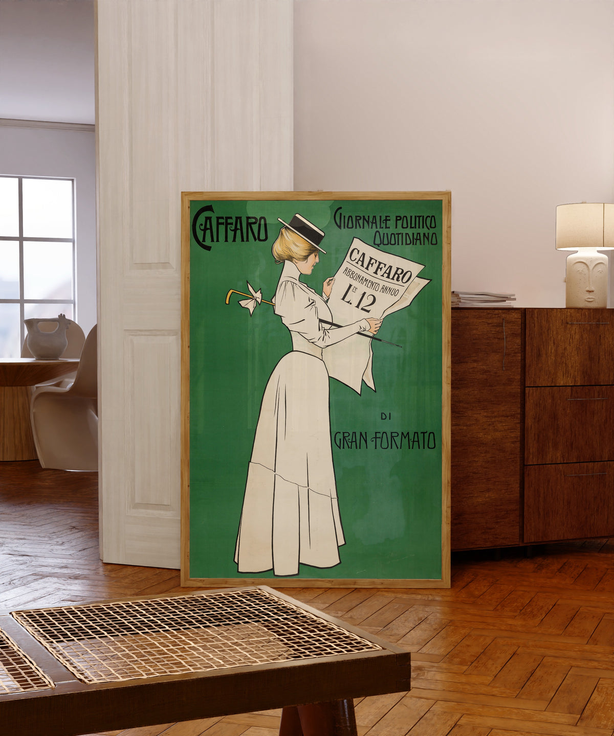 Framed art print of Caffaro: Giornale Politico Quotidiano di Gran Formato by Aleardo Villa, in a light wood frame leaning in a warm room with a parquet floor
