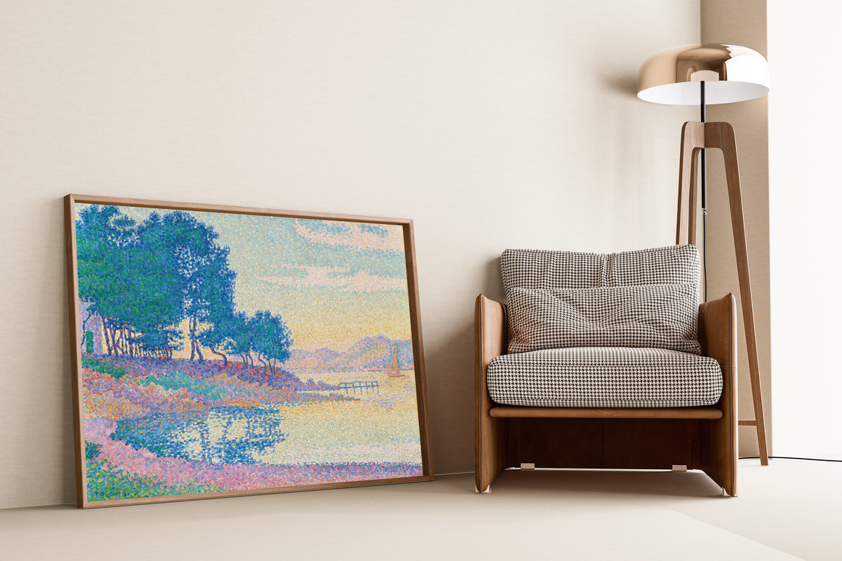Framed art print of Calanque des Canoubiers, Saint-Tropez by Paul Signac, leaning against a wall beside an armchair and a floor lamp
