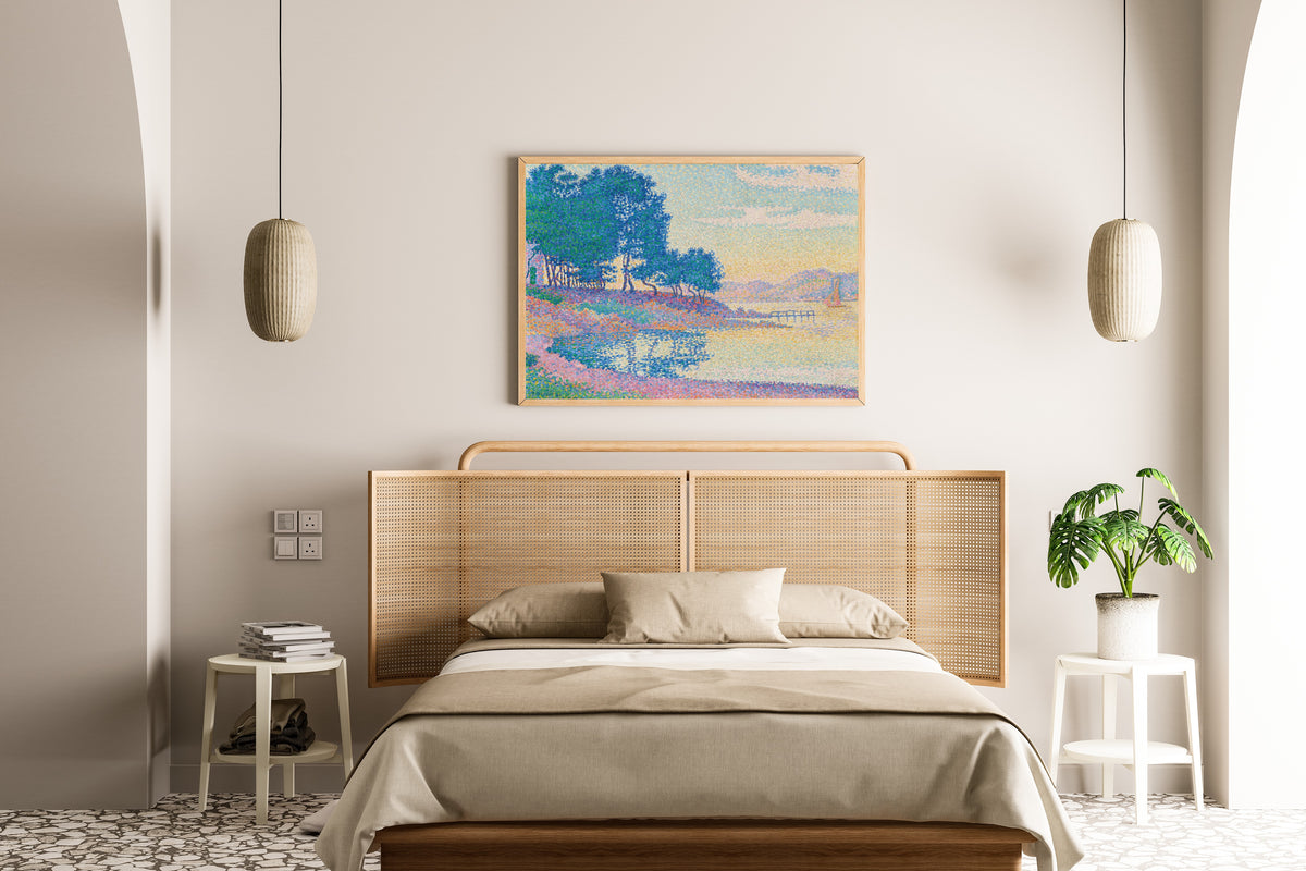 Framed art print of Calanque des Canoubiers, Saint-Tropez by Paul Signac, above a cane-headboard bed