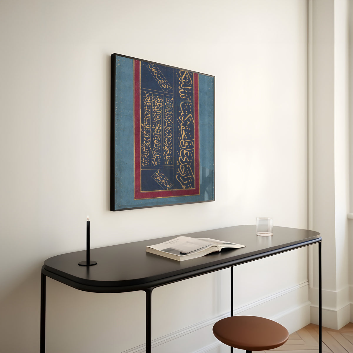 Framed art print of Calligraphy (Gold on Indigo) by Ahmad al-Husaini, above a slim black console table
