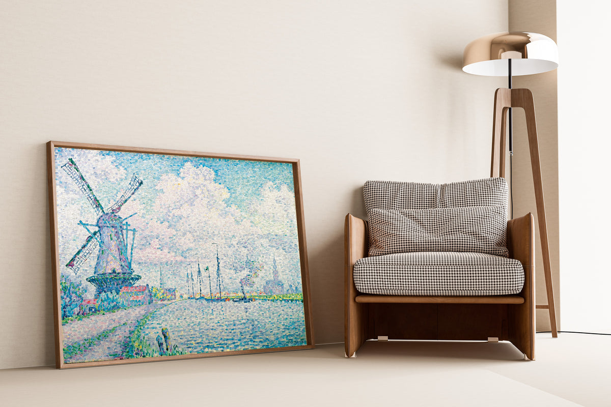 Framed art print of Canal of Overschie by Paul Signac, leaning against a wall beside an armchair and a floor lamp