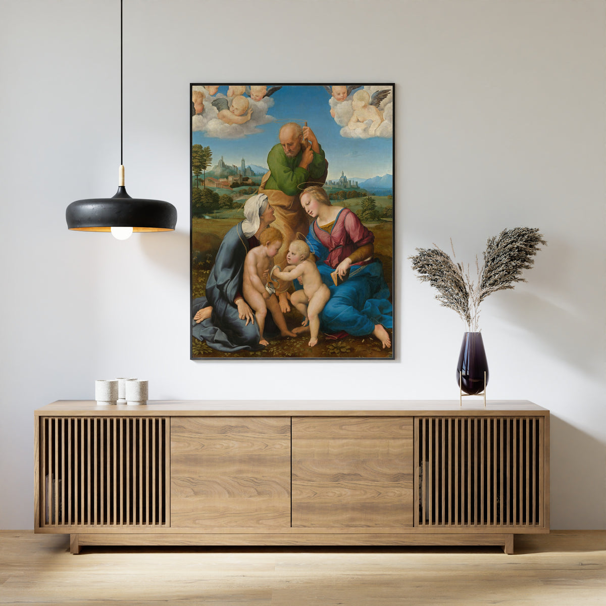 Framed art print of Canigiani Holy Family by Raphael, above a slatted wood sideboard