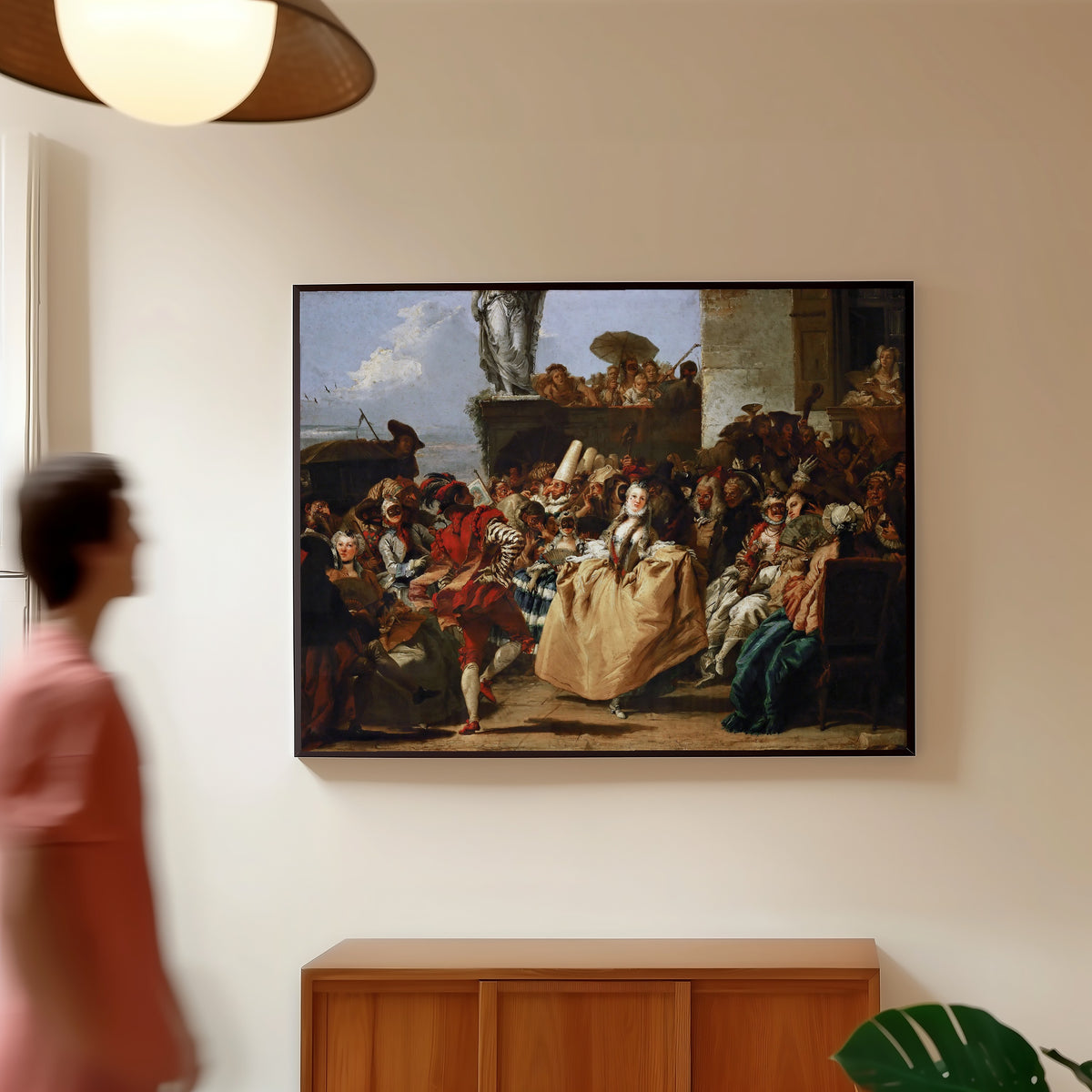 Framed art print of Carnival Scene (The Minuet) by Giovanni Domenico Tiepolo, in a slim black frame on a warm wall in a sunlit room