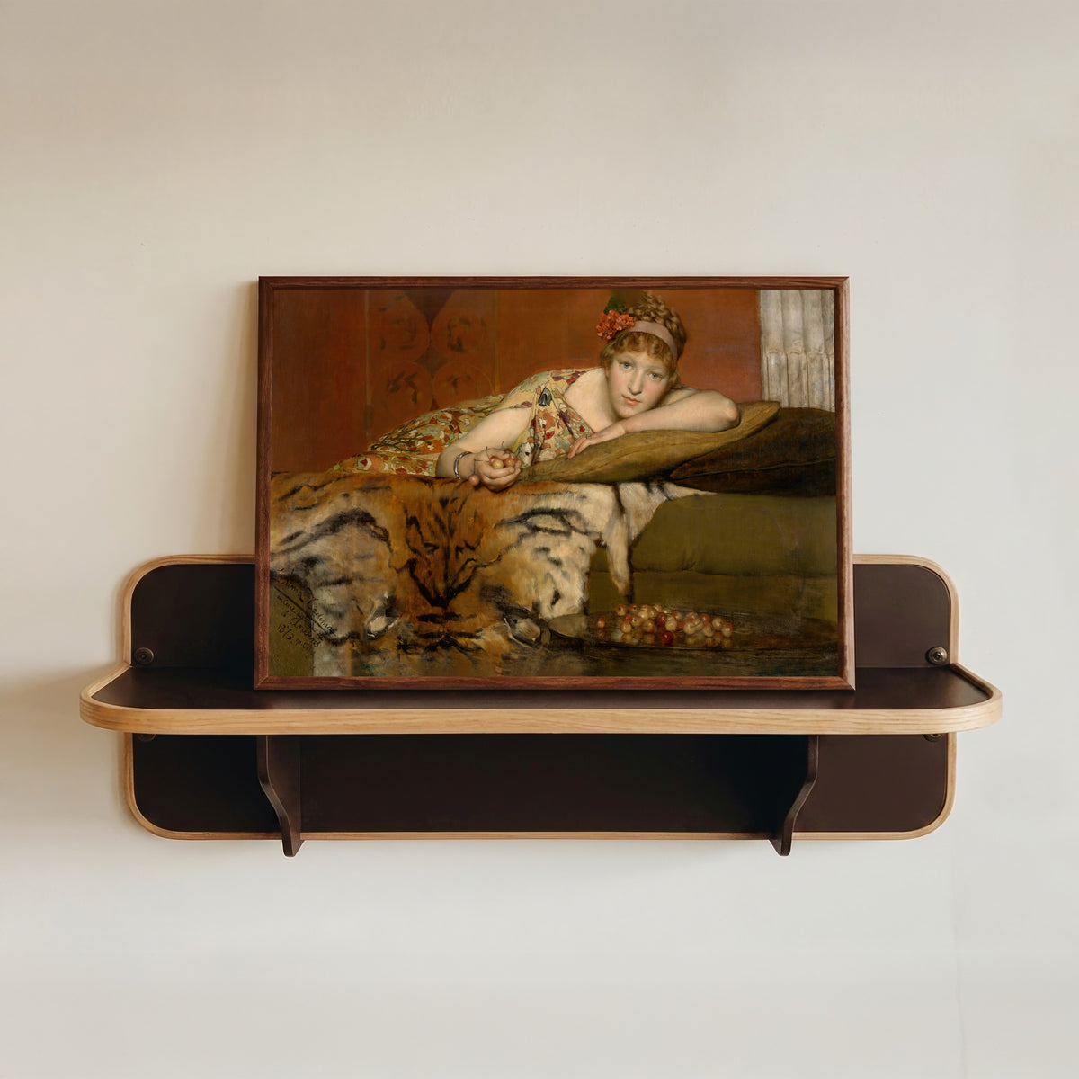 Framed art print of Cherries by Lawrence Alma-Tadema, in a dark wood frame resting on a wall shelf