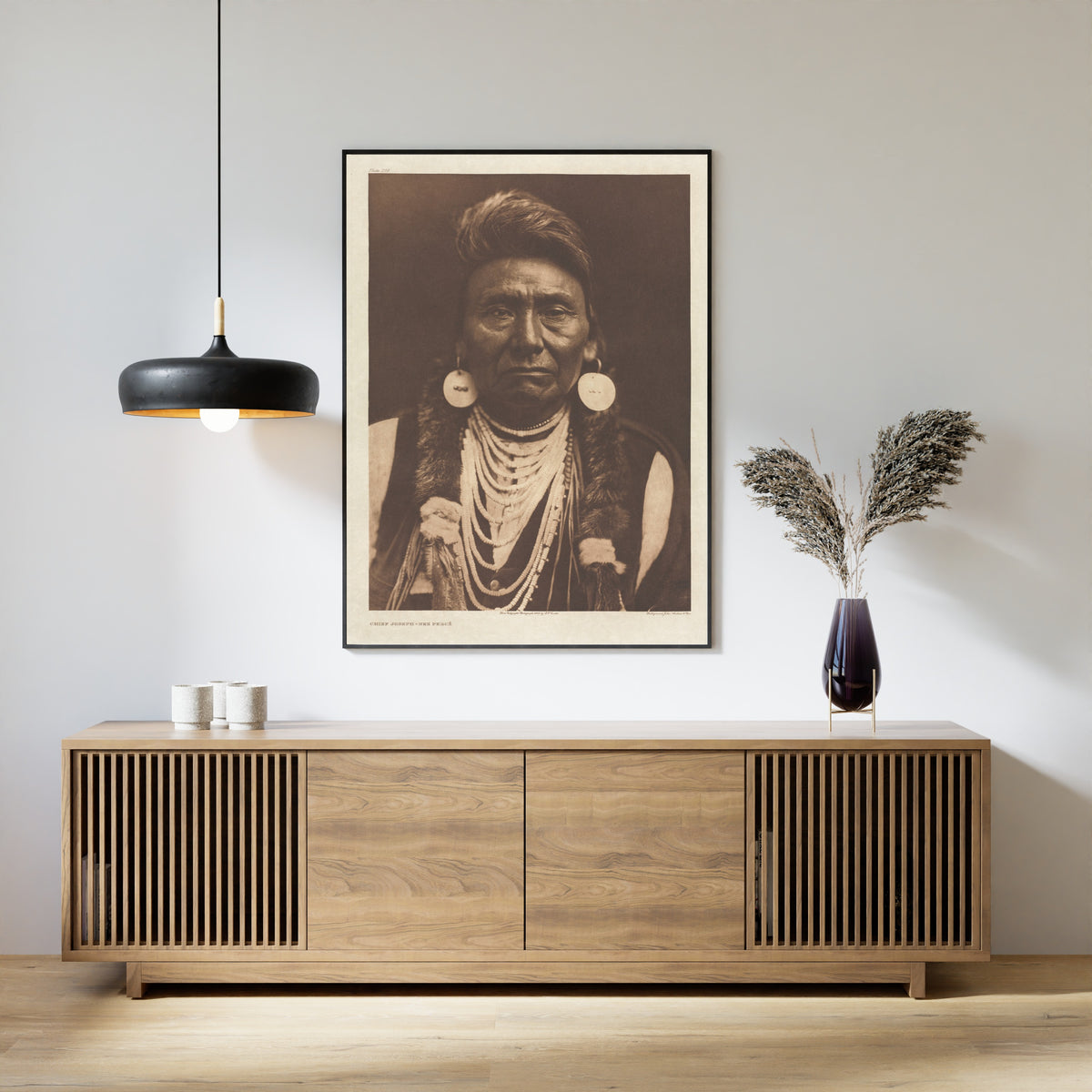 Framed art print of Chief Joseph, Nez Percé by Edward S. Curtis, above a slatted wood sideboard