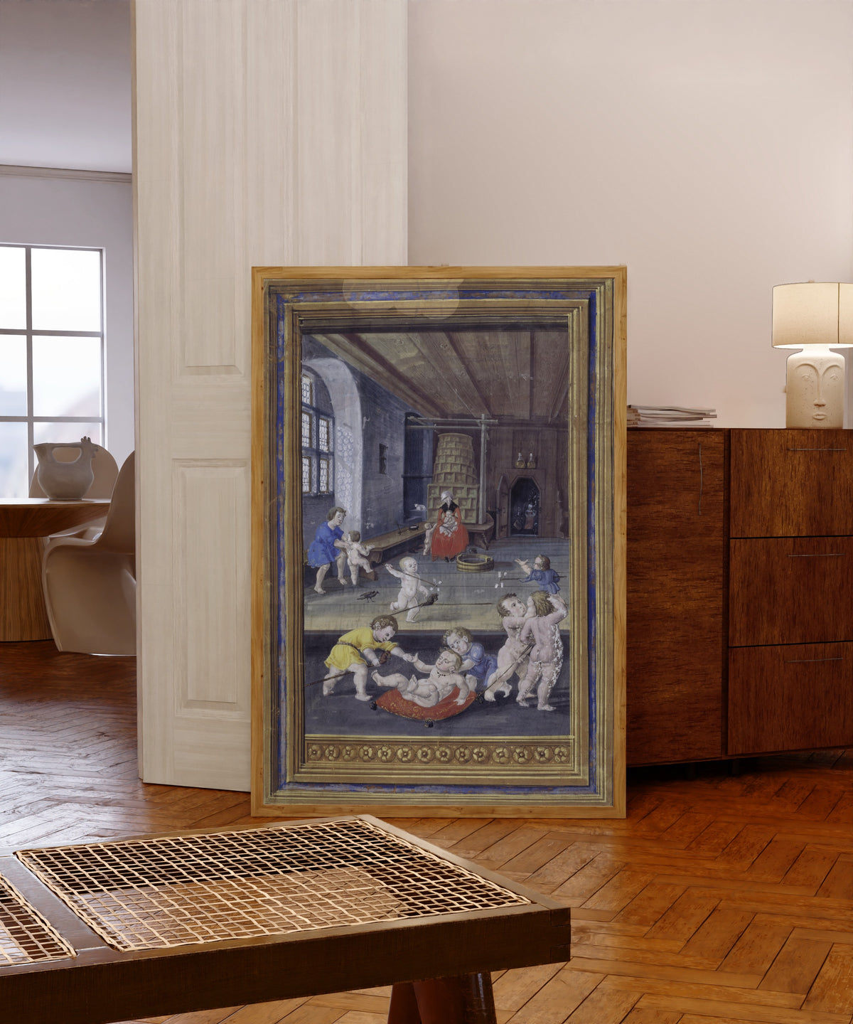 Framed art print of Children at Play by Splendor Solis, in a light wood frame leaning in a warm room with a parquet floor