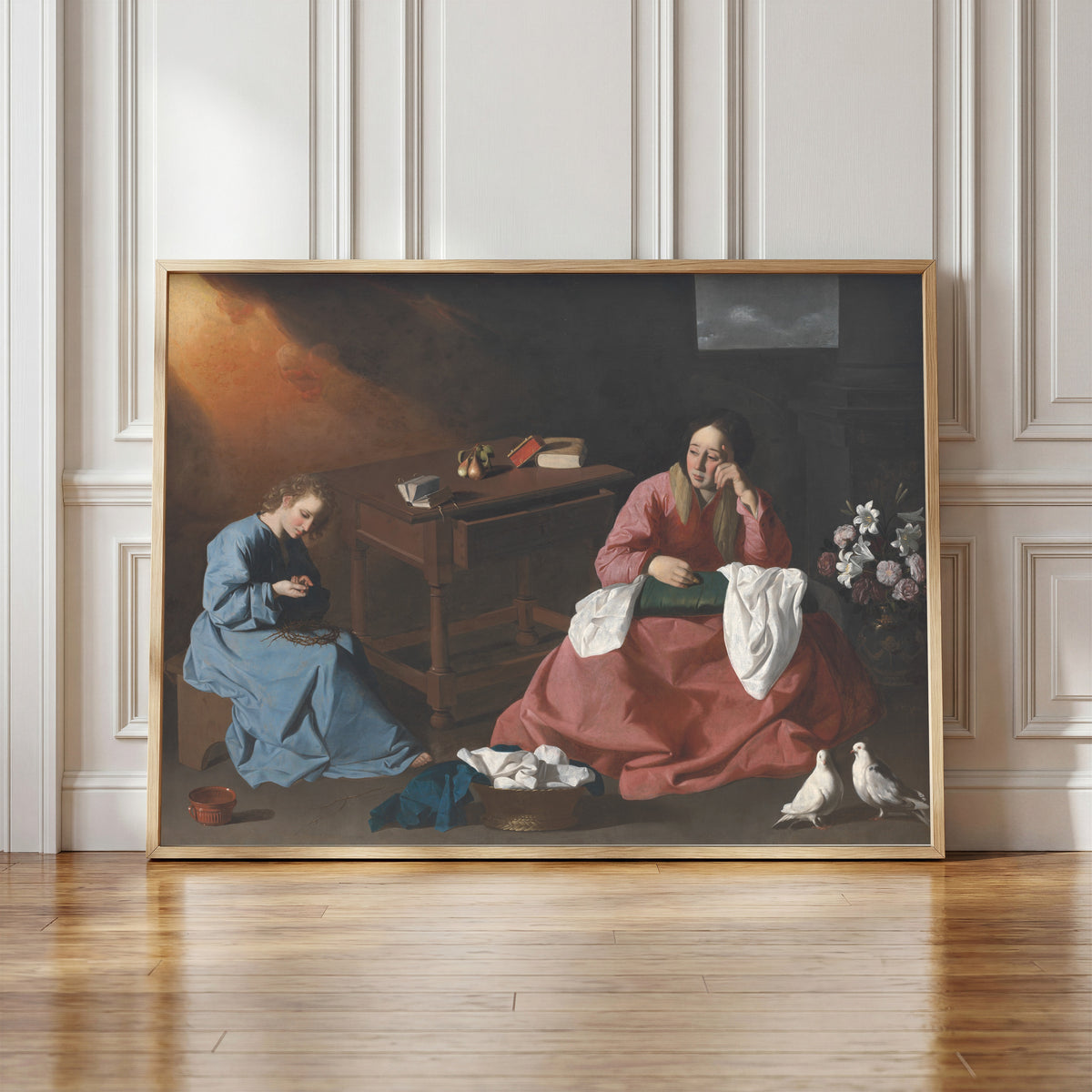 Framed art print of Christ and the Virgin in the House at Nazareth by Francisco de Zurbarán, in a light wood frame leaning against a panelled white wall