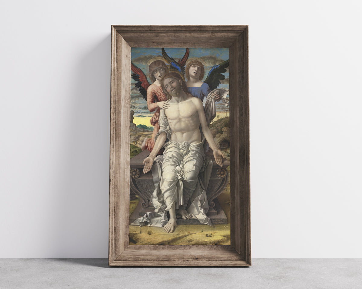 Framed art print of Christ as the Suffering Redeemer by Andrea Mantegna, in a wide wooden frame leaning against a concrete wall