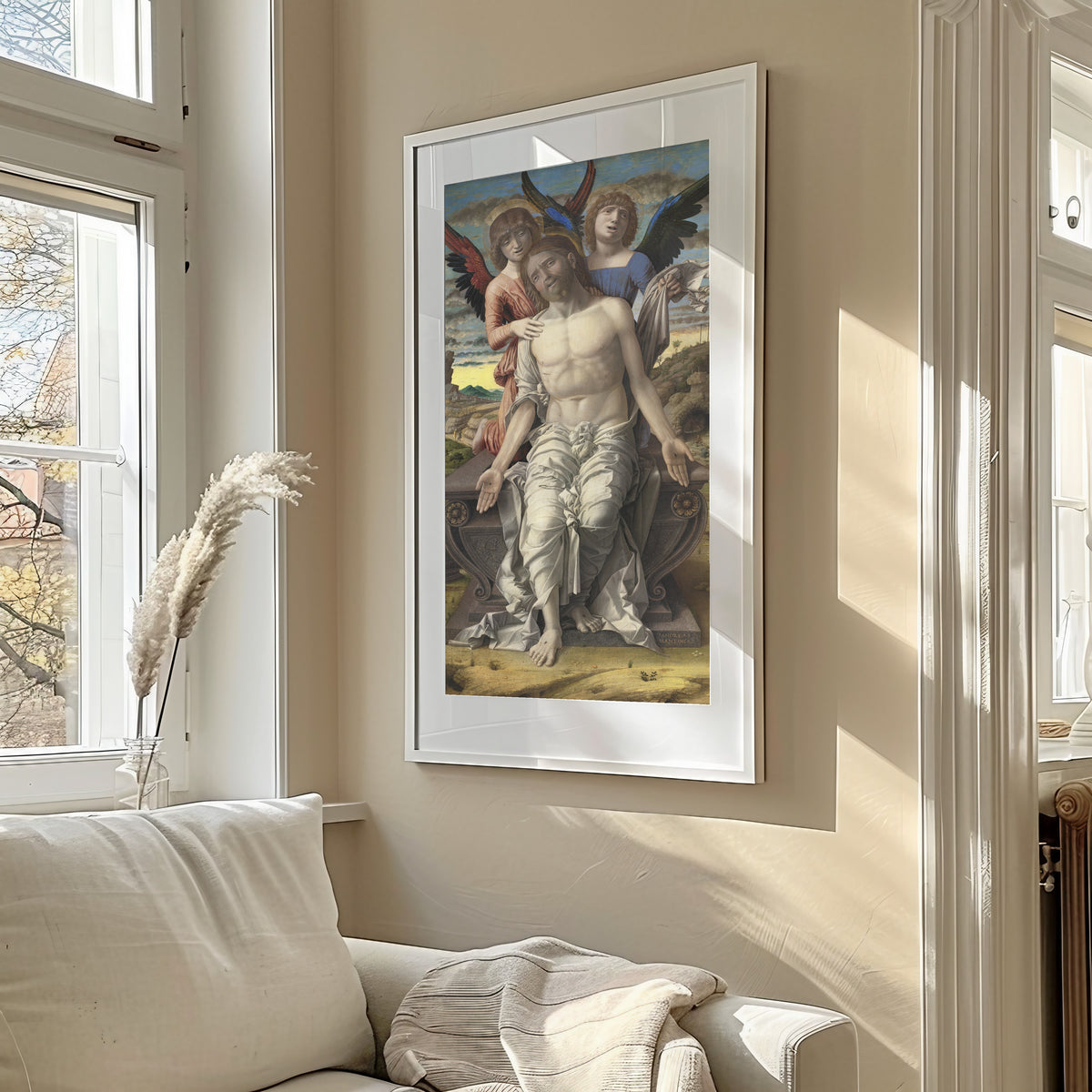 Framed art print of Christ as the Suffering Redeemer by Andrea Mantegna, in a sunlit living room above a sofa