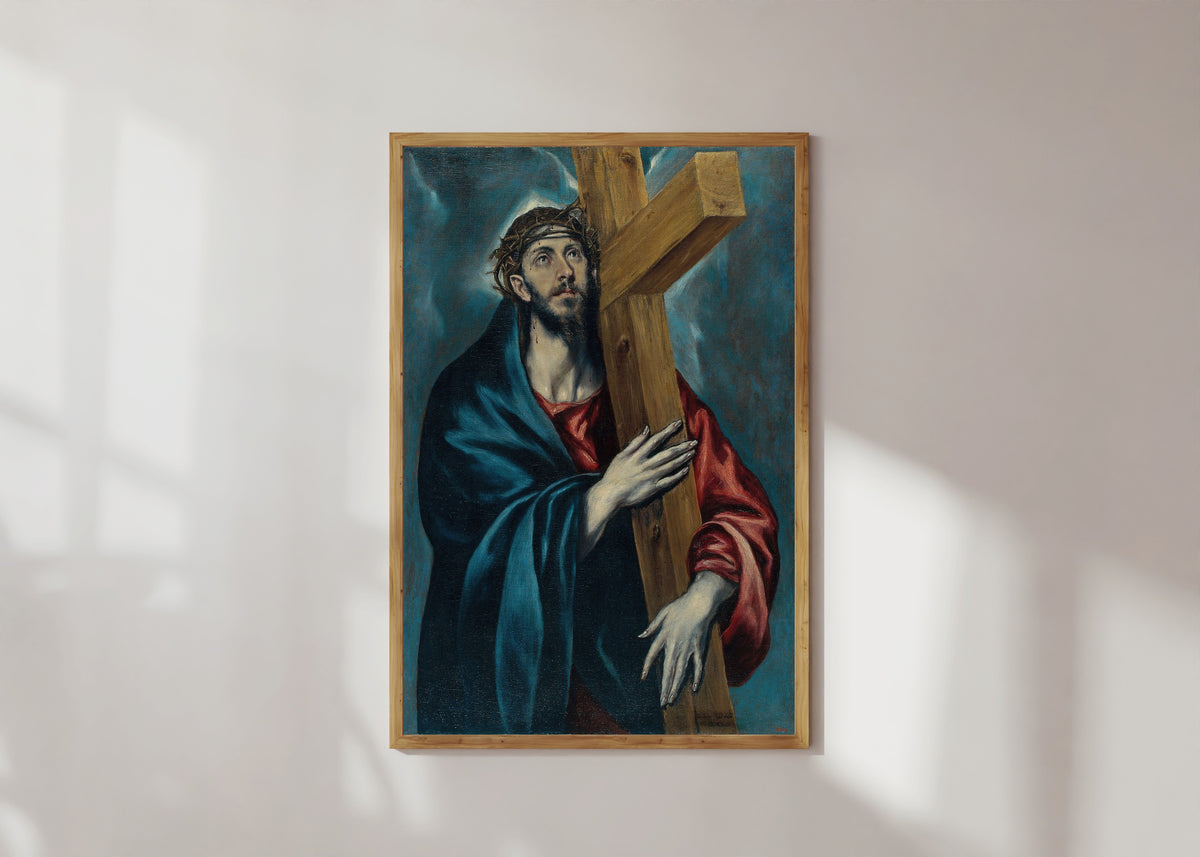 Framed art print of Christ with the Cross by El Greco, in a light wood frame on a sunlit white wall