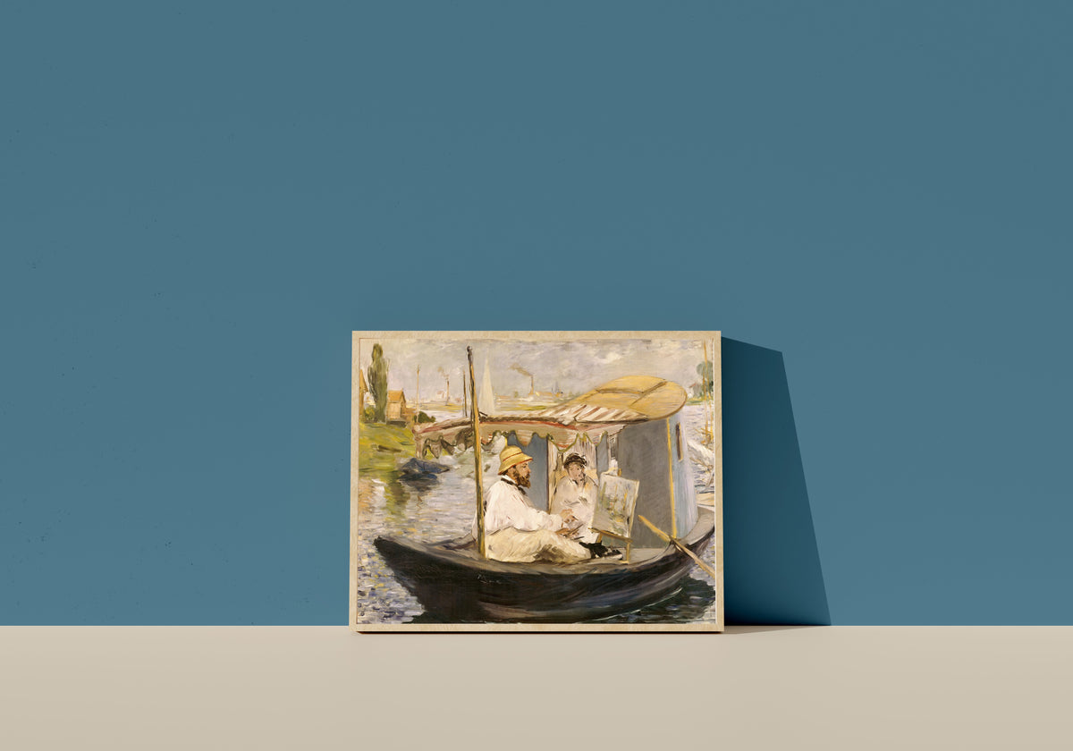 Framed art print of Claude Monet Painting in His Studio Boat by Édouard Manet, in a light wood frame leaning on a blue wall