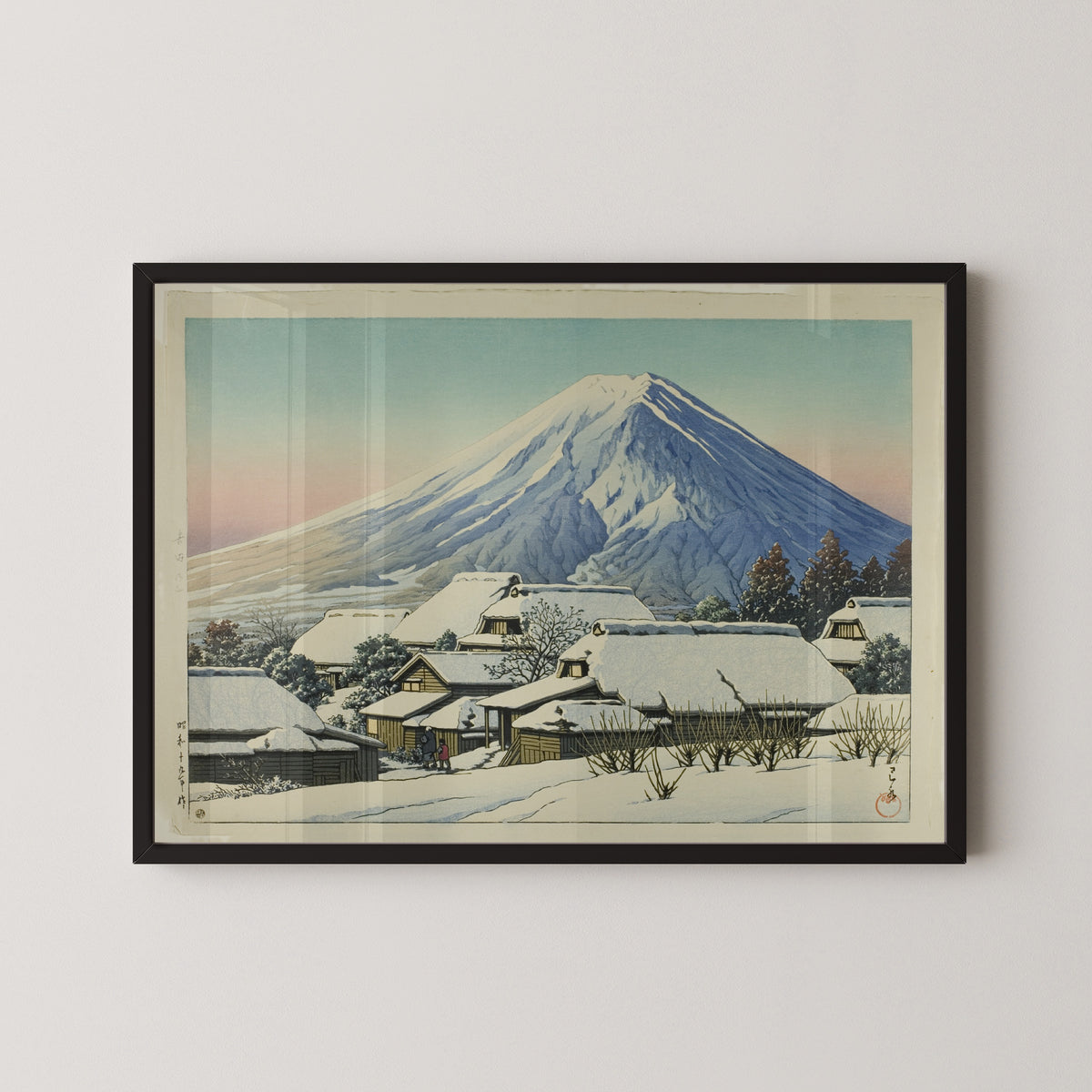 Framed art print of Clearing after a Snowfall, Yoshida by Kawase Hasui, in a black frame on a pale wall