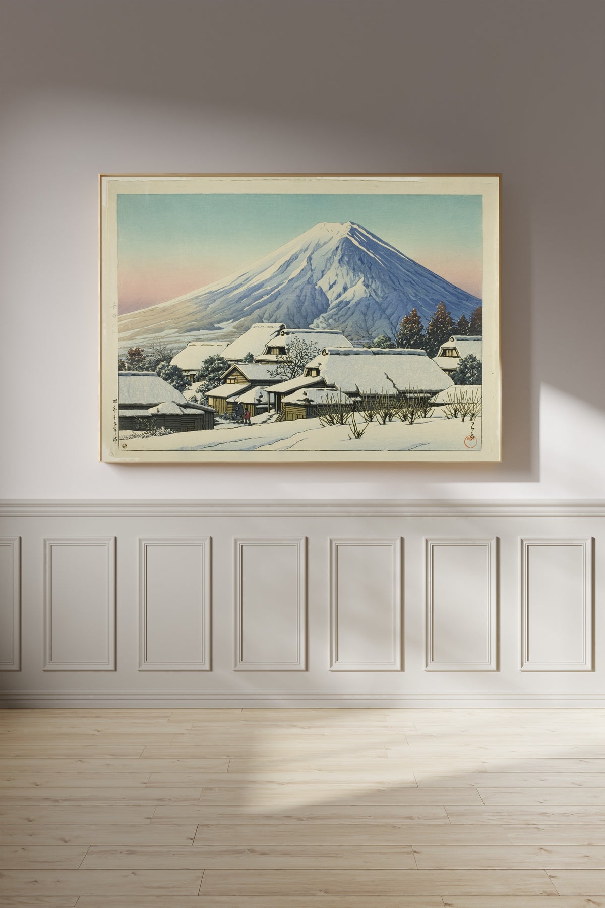 Framed art print of Clearing after a Snowfall, Yoshida by Kawase Hasui, on a panelled wall in afternoon light