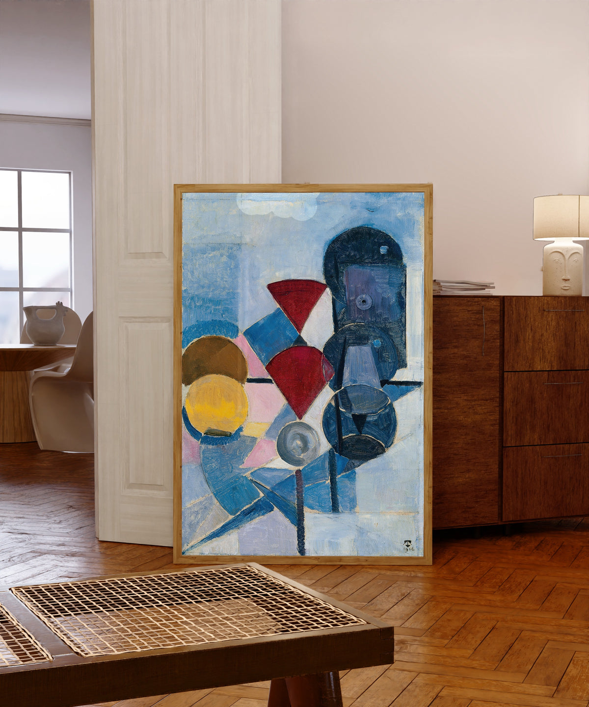 Framed art print of Composition II (Still Life) by Theo van Doesburg, in a light wood frame leaning in a warm room with a parquet floor